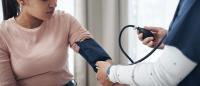 doctor checking a patient's blood pressure in an office